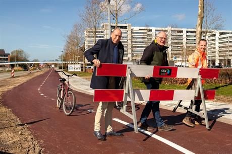 Wethouder Piet van Dijk en voorzitter van de fietsersbond Ton ten Brinke openen het fietspad door het laatste hek van het pad te verwijderen