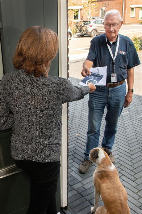 Een controleur aan de deur bij een hondeneigenaar
