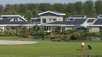 De golfbaan met op de achtergrond woningen van het Flevo Golf Resort